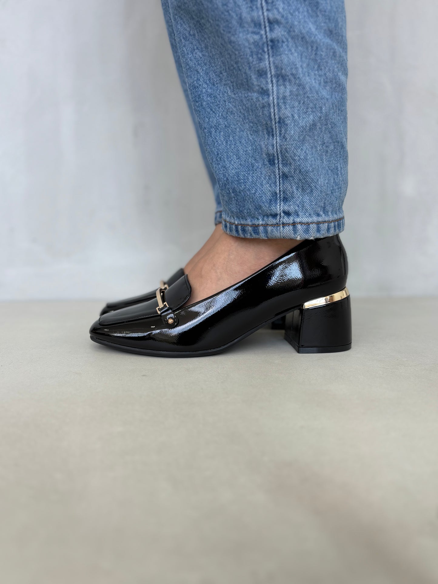 14256 – Zapatos negros de tacón medio con acabado charol y detalle dorado para dama