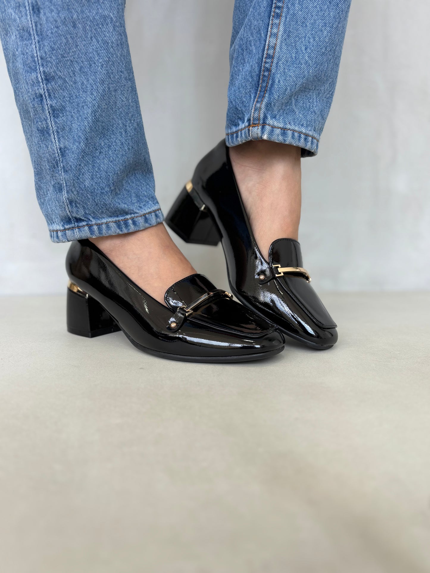 14256 – Zapatos negros de tacón medio con acabado charol y detalle dorado para dama