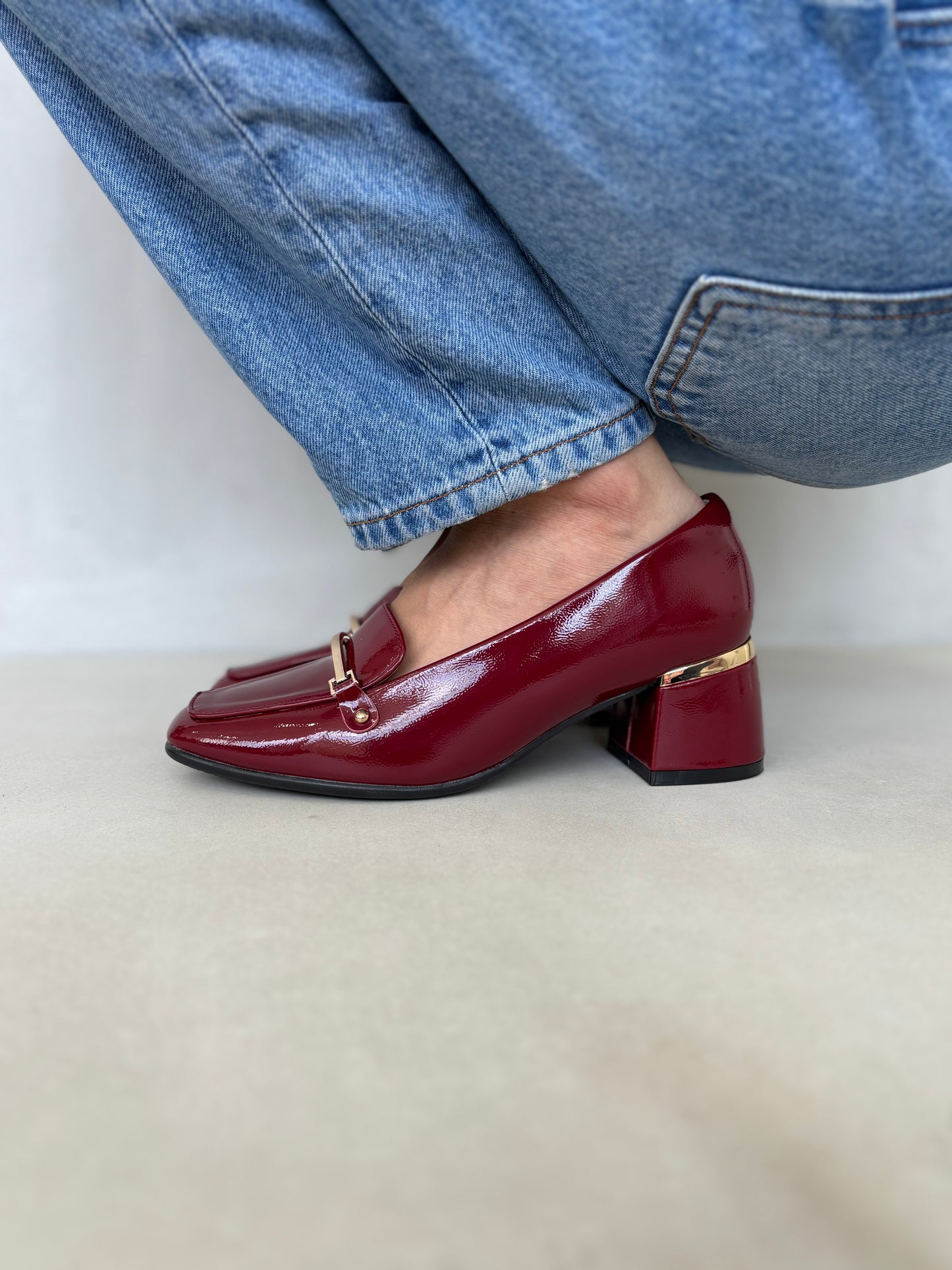 14257 – Zapatos burdeos de tacón medio con acabado charol y detalle dorado para dama