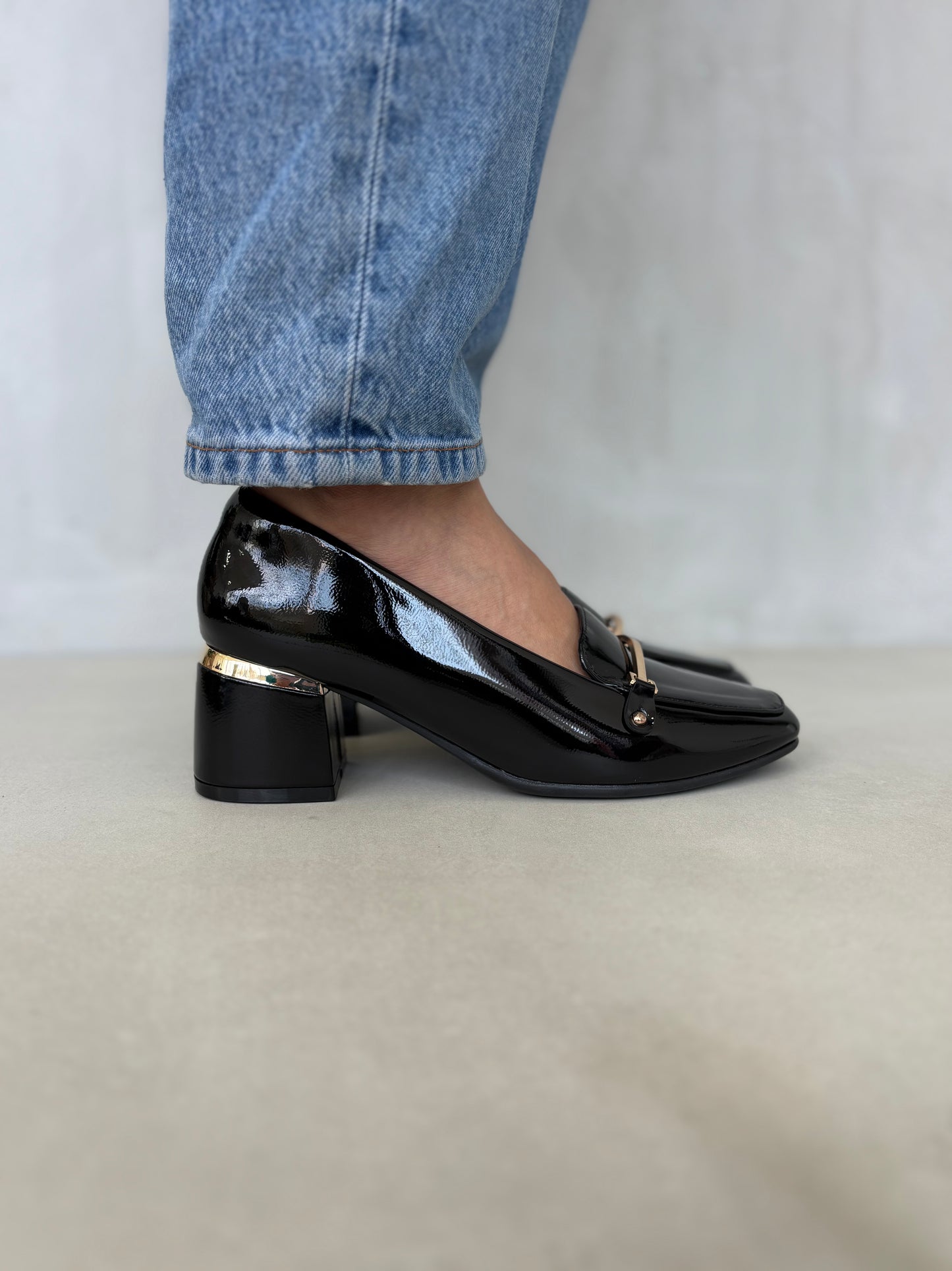 14256 – Zapatos negros de tacón medio con acabado charol y detalle dorado para dama